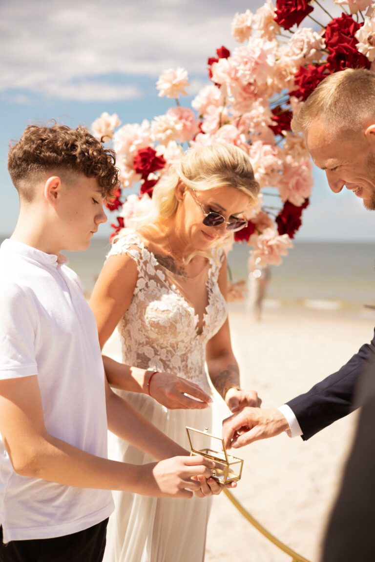 Panna młoda sięgająca po obrączki