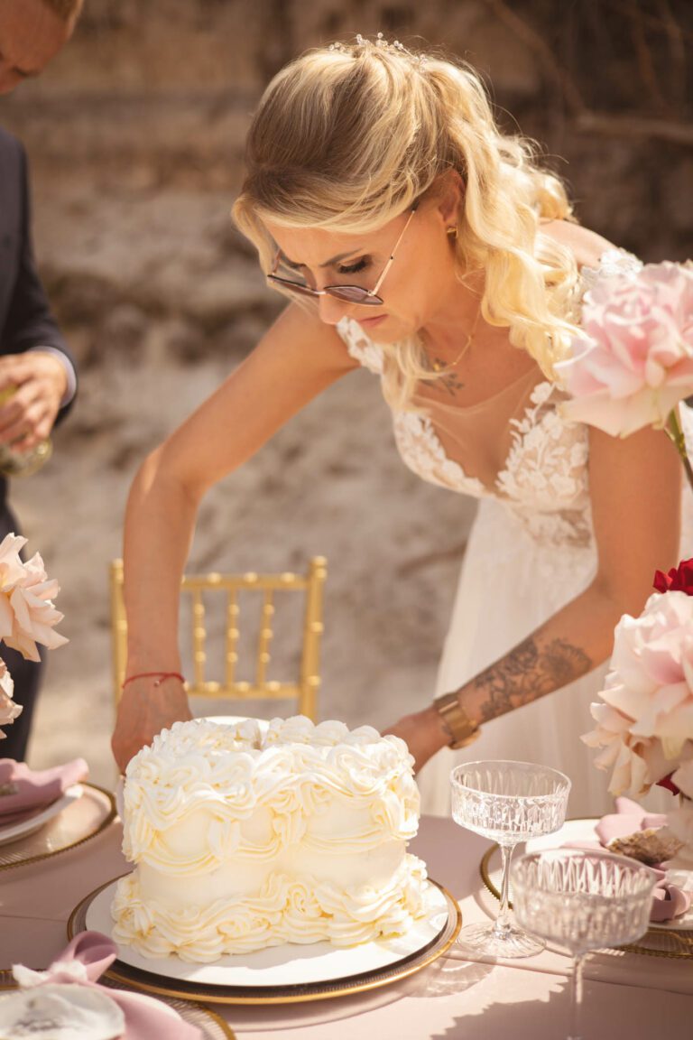 Panna młoda kroi tort na plaży